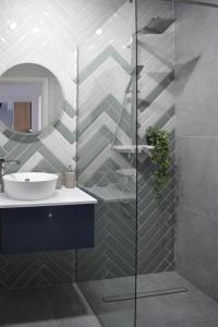 a bathroom with a sink and a mirror at Veles Apartments in Sibiu