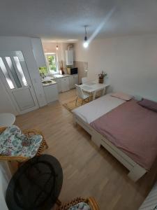 a bedroom with a large bed and a kitchen at Apartman Medrese in Sarajevo