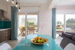 una cucina e un soggiorno con tavolo e cesto di frutta di Thalassa Apartment Ierapetra a Ierápetra
