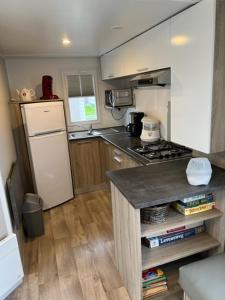 a small kitchen with a stove and a refrigerator at Luxe stacaravan in Middelkerke