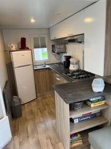 een kleine keuken met een fornuis en een koelkast bij Luxe stacaravan in Middelkerke