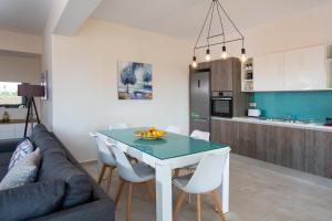 a kitchen and living room with a table and chairs at Thalassa Apartment Ierapetra in Ierapetra +24 photos