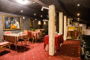 a restaurant with tables and chairs and a painting on the wall at Hotel Akvamarin in Leninogorsk