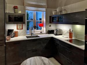 a kitchen with a sink and a microwave at Le Clos du Vieux Porche in La Couarde-sur-Mer +6 photos