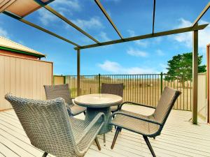 a patio with a table and chairs on a deck at King 2 - close proximity to Bimbadgen and Hope Estate concerts in Pokolbin