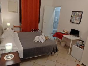 een slaapkamer met een bed en een bureau met een laptop bij B&B Toscana in Pisa