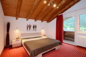 een slaapkamer met een bed en een groot raam bij Zentrum Appartements Lorenzin in Gaschurn