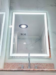 a mirror above a sink in a bathroom at Luxurious Room near LaGuardia & JFK in Corona +12 photos