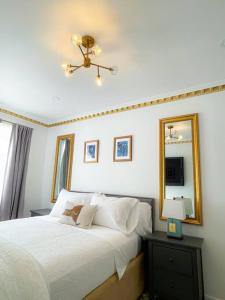 a bedroom with a white bed with a mirror and a lamp at Luxurious Room near LaGuardia & JFK in Corona