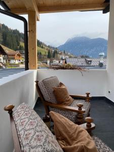 a balcony with two chairs and a view of a mountain at B&B CAMPITELLO 13 di Caterina Costan in San Niccolò Comèlico