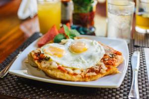 un plato de comida con un huevo en una mesa en Bocawina Rainforest Resort, en Hopkins