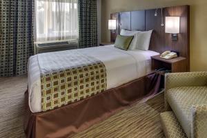 una camera d'albergo con un grande letto e una sedia di The Stevenson Monterey a Monterey