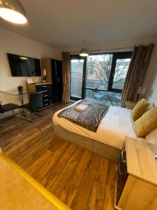 Un dormitorio con una cama grande con un escritorio y un teclado. en Empire Serviced Apartments, en Leicester
