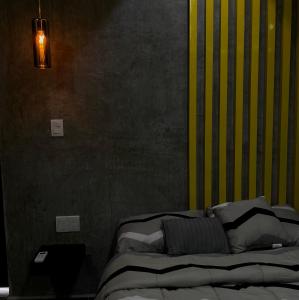 - une chambre avec un lit et un mur jaune et noir dans l'établissement Türk, à Chetumal