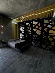 um quarto com uma cama e piso em madeira em Türk em Chetumal