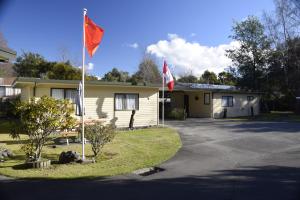 two flags flying in front of a house at Judges Pool Motel Turangi in Turangi