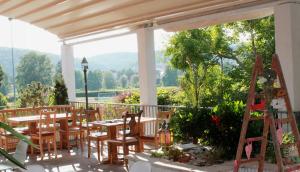 un patio con mesas y sillas en el balcón en Gasthof Via Vita, en Treuchtlingen