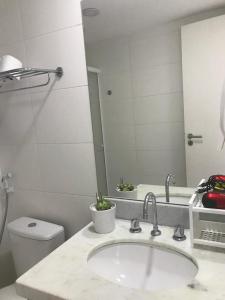 a bathroom with a sink and a toilet and a mirror at RIOSTAY Riocentro Apart-Hotel in Rio de Janeiro +10 photos