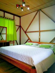 a bedroom with a large bed with a green curtain at Rio Napo Lodge in Puerto Misahuallí