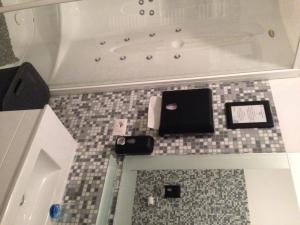 a bathroom with a bath tub with electronics on the floor at B&B La Terrazza Sul Mare Taormina in Taormina