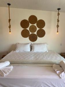 ein Schlafzimmer mit einem weißen Bett mit vier braunen Kreisen an der Wand in der Unterkunft Casa Éolica in Barra Grande