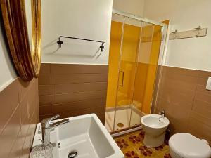 een badkamer met een wastafel, een toilet en een douche bij Palazzo Lupicini Affittacamere in Bisceglie