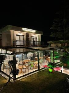 a large building with glass doors and tables on it at Dalyan Risus Suite in Cesme