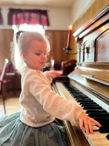 a little girl is playing on a piano at Hotel Zur Sonne in Falkenstein