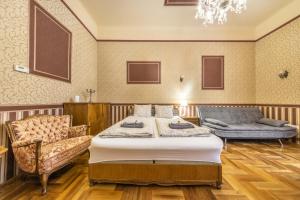 a bedroom with a bed and a couch and a chair at Josephine Studio in Budapest