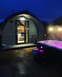 uma banheira com luzes roxas num quarto em Thistle Pod at Ayrshire Rural Retreats Farm Stay Hottub Sleeps 2 em Galston
