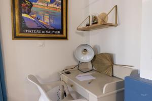 escritorio con lámpara y silla en una habitación en Chez Gaspéli en Saumur