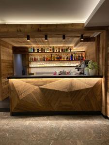 a bar with a wooden counter top in a room at Hotel Ariston ***S in Madonna di Campiglio