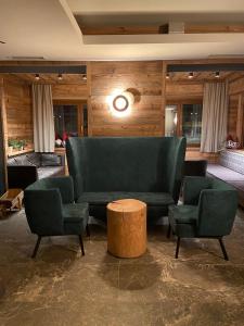 a living room with two chairs and a couch at Hotel Ariston ***S in Madonna di Campiglio