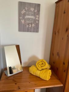 a wooden shelf with a yellow towel and a box at Anvil Cottage in Mold +40 photos