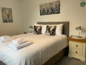 a bedroom with a bed with two towels on it at Anvil Cottage in Mold