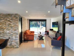 a living room with an orange couch and a brick wall at Maison piscine jeux à la campagne in Camélas