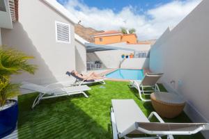 a small backyard with lawn chairs and a swimming pool at Villa Santiago in La Playa de Tauro