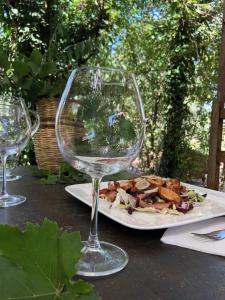 un piatto di cibo su un tavolo con un bicchiere di vino di La casa nel bosco a Lari