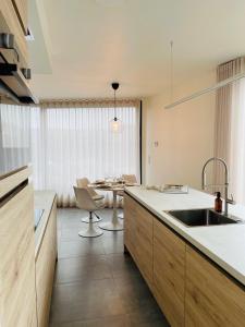 een keuken met een wastafel en een tafel bij Your Room with A View Bolderberg in Heusden - Zolder