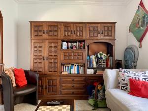 a large wooden cabinet in a living room with a couch at Manelisa Cascais in Cascais