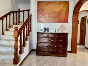 a wooden dresser in a hallway with a staircase at Manelisa Cascais in Cascais