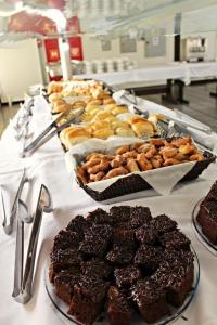 a table topped with different types of cakes and desserts at Pousada Pontal de Guaratuba in Guaratuba