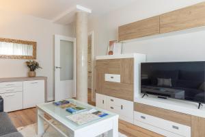 uma sala de estar com uma televisão grande e uma mesa de centro em El Rincón del Condado by Asturias Holidays em Noreña