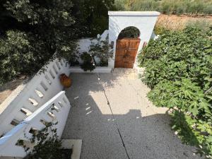 サン・ヴィート・デイ・ノルマンニにあるMasseria Principe di Pugliaの庭の白い柵と木製の扉