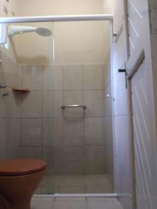 a bathroom with a glass shower with a toilet at Pousada Vila do Sonho in Paraty