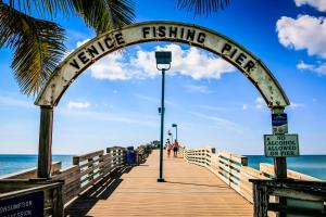 a wooden pier with an archway on the beach at Tropical Villas Of Venice Beach in Venice