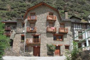 un gran edificio de piedra con balcones de madera. en Casa La Lourdes, en Ainet de Besan