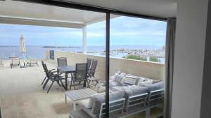 een woonkamer met een bank en een tafel op een balkon bij Beachfront Es Turo in Colonia Sant Jordi
