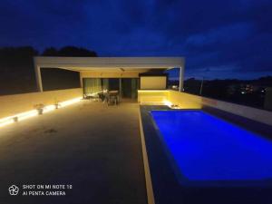 a house with a swimming pool at night at Beachfront Es Turo in Colonia Sant Jordi