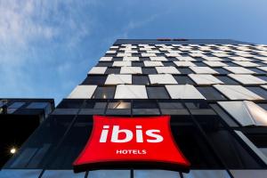 
a red and white sign on a building at ibis Adelaide in Adelaide
